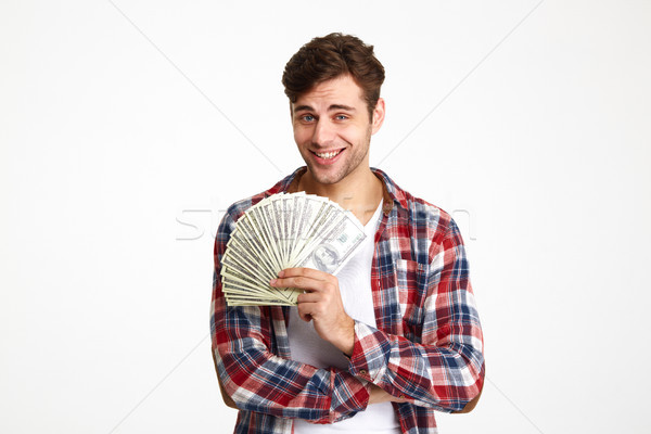 Portrait of a young man holding bunch of money banknotes Stock photo © deandrobot