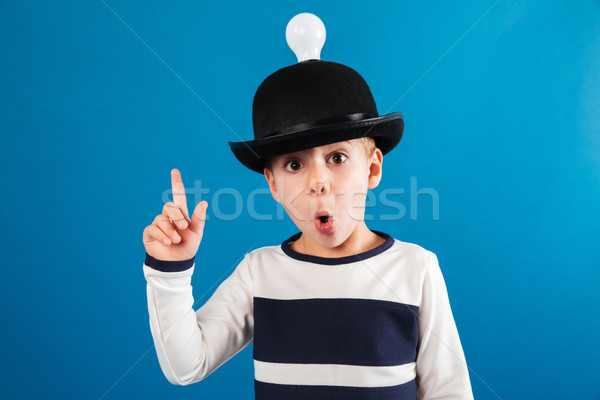 Shocked young boy in hat with lightbulb having idea Stock photo © deandrobot