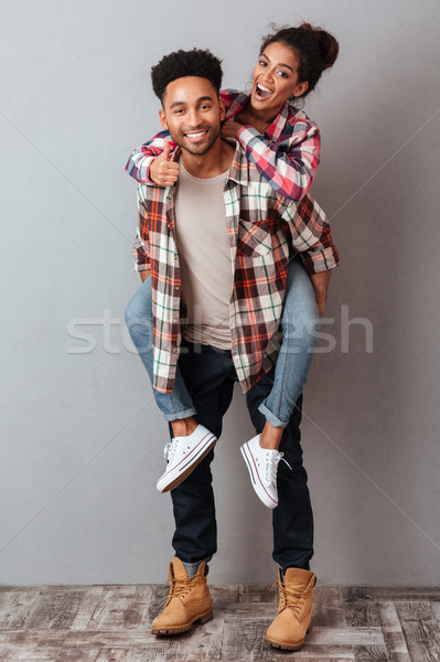 Full length portrait of a smiling young african man Stock photo © deandrobot