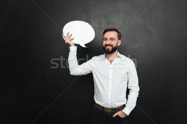 Good-looking brunette man holding blank speech bubble and lookin Stock photo © deandrobot