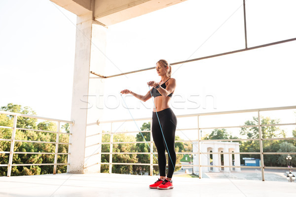 Stock photo: Young beautiful sports woman jumping with skipping rope