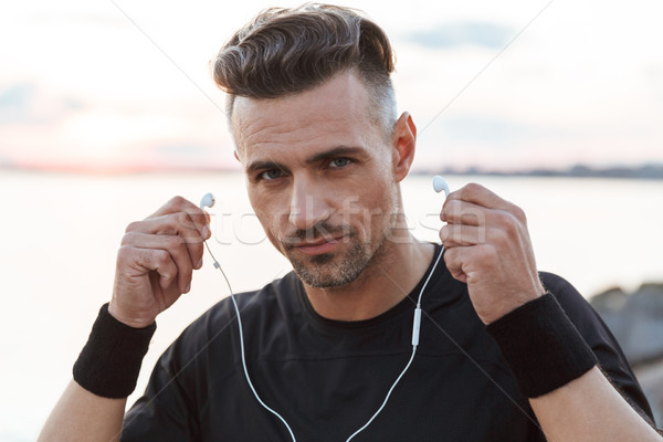 Close up portrait of a confdent sportsman listening to music Stock photo © deandrobot