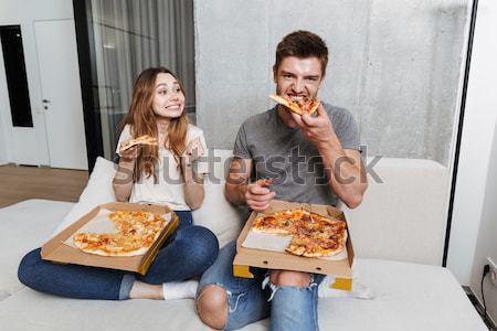 Satisfied young couple eating pizza Stock photo © deandrobot