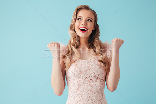 Cheerful blonde woman in dress rejoices and looking up Stock photo © deandrobot