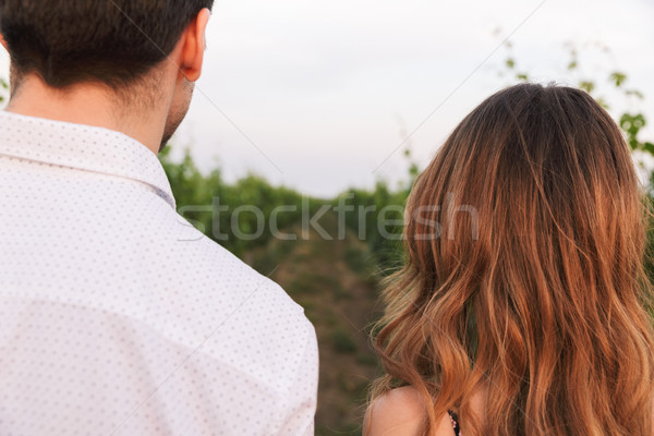 Photo from back closeup of young couple man and woman, walking t Stock photo © deandrobot