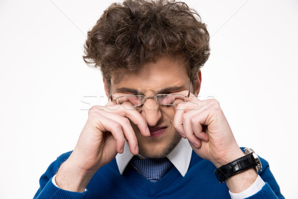Young businessman rubbing his eyes over white background Stock photo © deandrobot