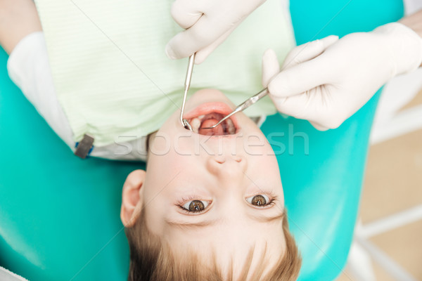 Boy with mouth opened during oral inspection in dental clinic Stock photo © deandrobot