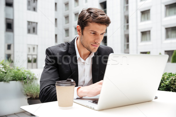 Businessman using laptop in outdoor cafe Stock photo © deandrobot