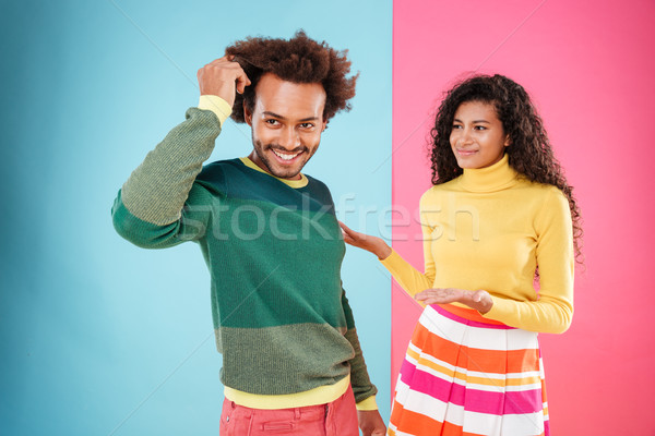 Cheerful confident man standing in front of his confused girlfriend Stock photo © deandrobot