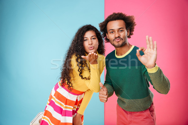 Happy african young couple sending kiss and showing ok sign Stock photo © deandrobot