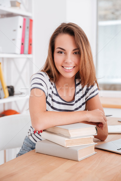 Pretty student girl has leaned the elbows on books Stock photo © deandrobot