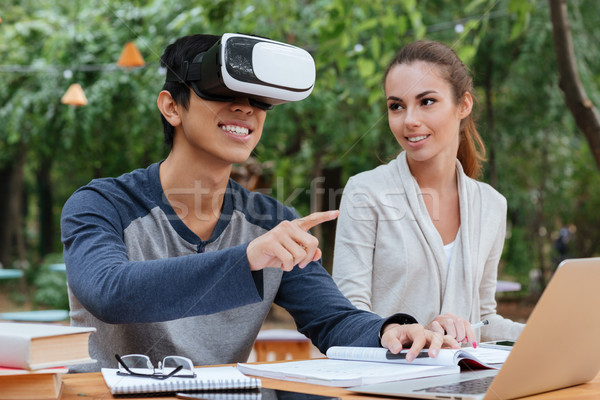 Happy young couple using virtual reality glasses outdoors Stock photo © deandrobot