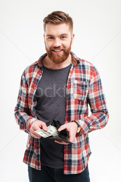 Smiling man in plaid shirt putting money in his wallet Stock photo © deandrobot