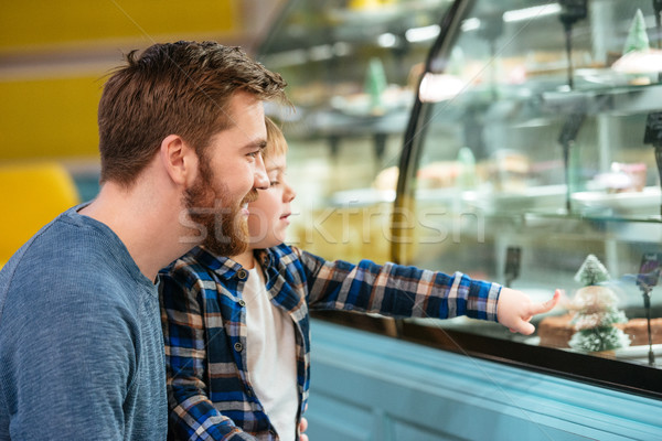 Happy father and little son choosing cake in showcase Stock photo © deandrobot