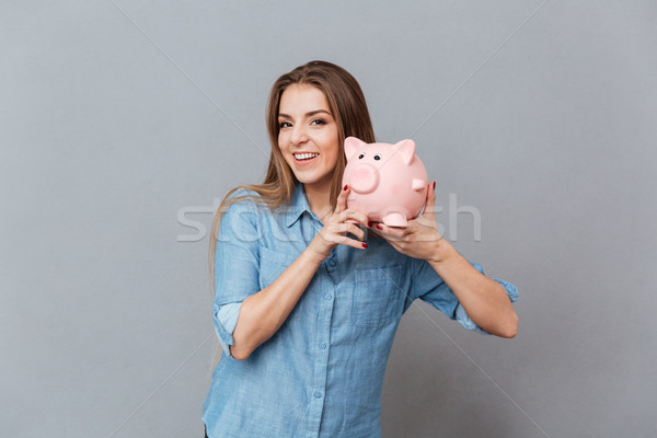 Woman in shirt holding moneybox in hands Stock photo © deandrobot