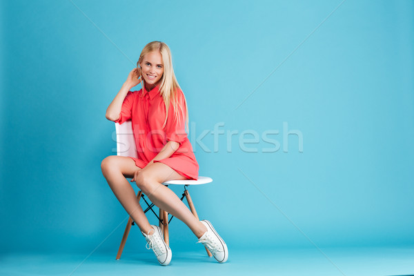 случайный женщину красное платье сидят глядя камеры Сток-фото © deandrobot