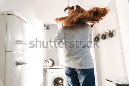 Woman in fur coat takind jar with fish from shelf Stock photo © deandrobot