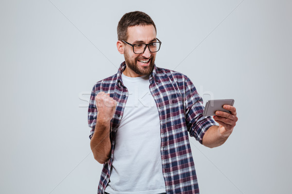 Foto stock: Feliz · barbado · hombre · mirando · teléfono · aislado