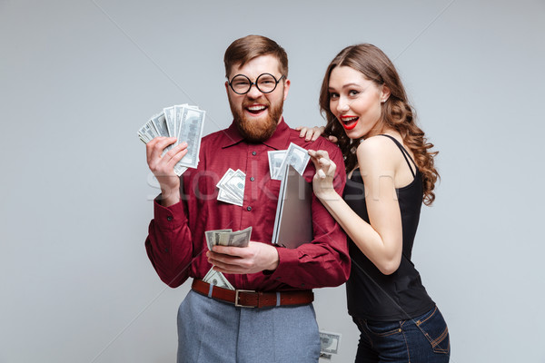 Cunning Woman stick to Male nerd with money Stock photo © deandrobot