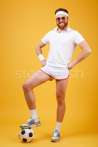 Handsome happy young sportsman isolated over yellow background Stock photo © deandrobot