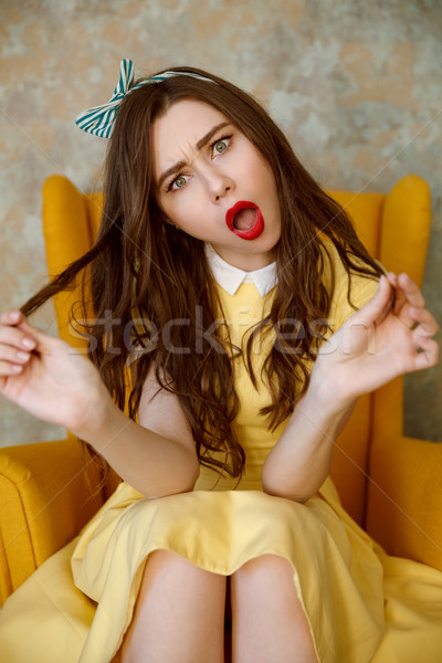 Függőleges kép mérges nő fotel citromsárga Stock fotó © deandrobot