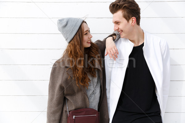 Cheerful young couple standing and looking at each other Stock photo © deandrobot