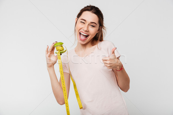 Portrait of an excited playful girl holding half eaten apple Stock photo © deandrobot
