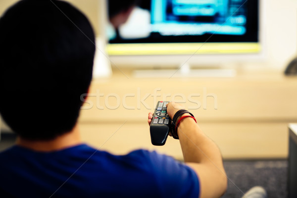 Vedere din spate portret om vizionarea televizor acasă Imagine de stoc © deandrobot