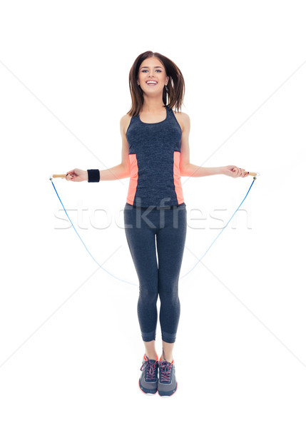 Happy woman doing exercises with jumping rope Stock photo © deandrobot