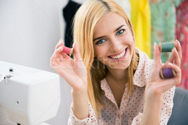 Smiling female deisgner holding thread Stock photo © deandrobot