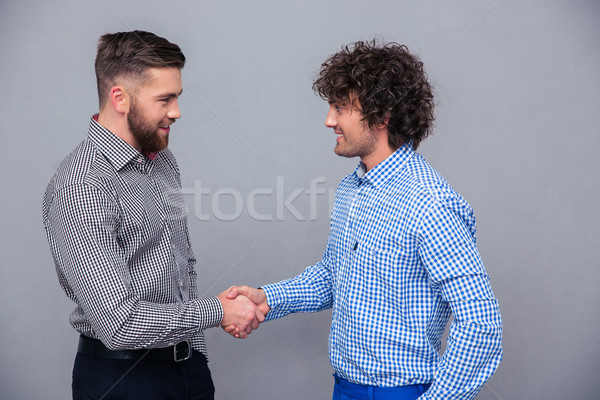 Portrait of a two casual men doing handshake Stock photo © deandrobot