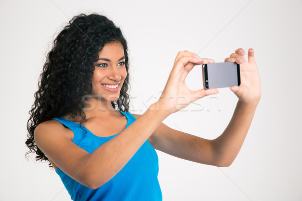 Smiling afro american woman making selfie photo  Stock photo © deandrobot