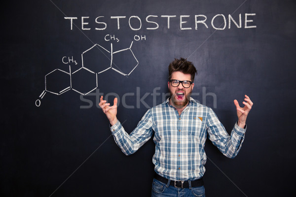 Crazy professor of chemistry standing and shouting over chalkboard background Stock photo © deandrobot