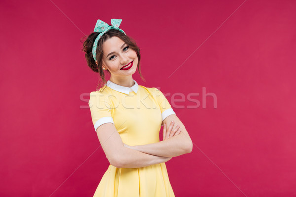 商業照片: 微笑 · 年輕女子 · 黃色 · 穿著 · 常設 · 雙臂交叉