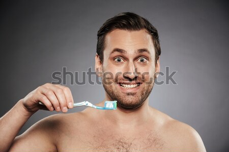 Heureux nu jeune homme nettoyage dents brosse à dents [[stock_photo]] © deandrobot