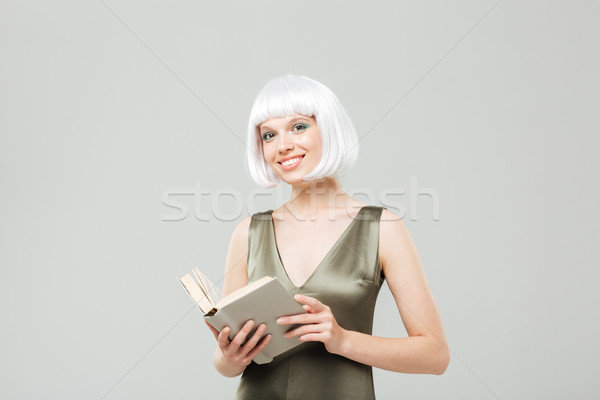 Zâmbitor par blond lectură carte alb Imagine de stoc © deandrobot