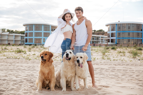 Romantic young couple standing on the sea shore with dog Stock photo © deandrobot