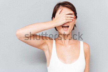 Portrait of a young woman covering her eyes with palm Stock photo © deandrobot