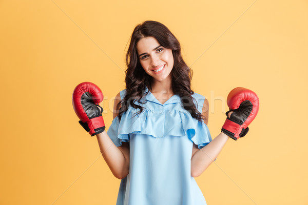 Stock photo: Happy casual brunette woman wearing boxing gloves