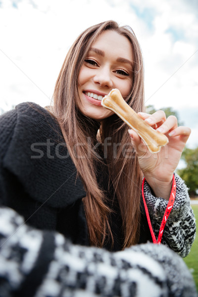 Derűs gyönyörű fiatal nő tart csont kutya Stock fotó © deandrobot