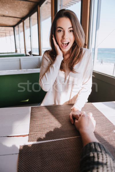 Vertical image surprised woman on date in cafe near sea Stock photo © deandrobot
