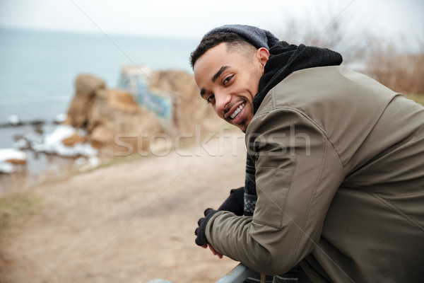 Young handsome african man walking on the street. Stock photo © deandrobot