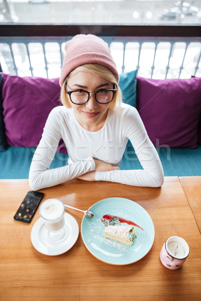 Cheerful young woman eating cake and drinking coffee Stock photo © deandrobot