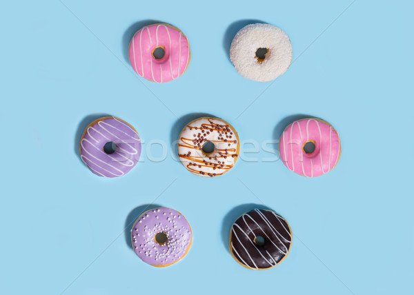 Sweeties donuts over blue table background. Stock photo © deandrobot