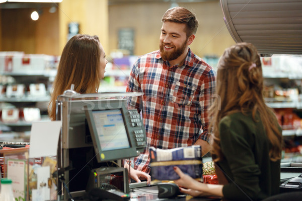 Happy young loving couple standing near cashier's desk Stock photo © deandrobot
