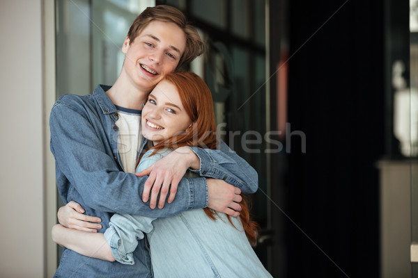 Stock photo: Young man and woman looking camera while hugging