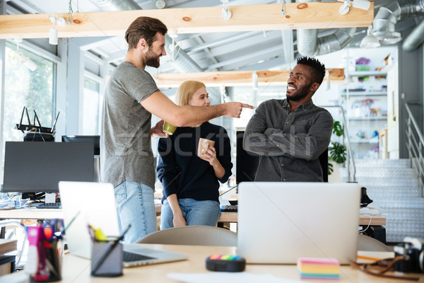 ?appy young colleagues standing in office coworking Stock photo © deandrobot