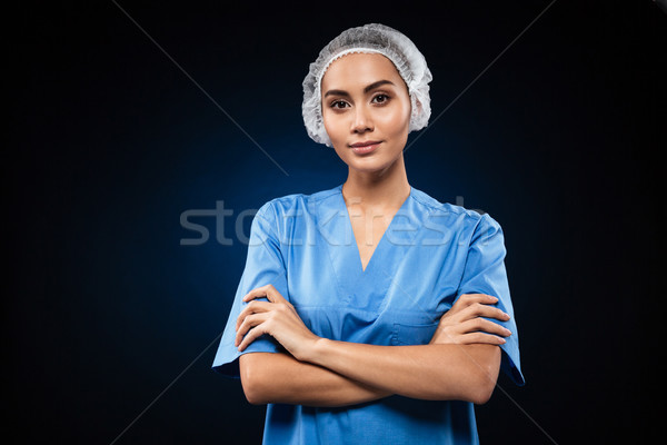 Sérieux médecin regarder caméra mains tenant pliées [[stock_photo]] © deandrobot