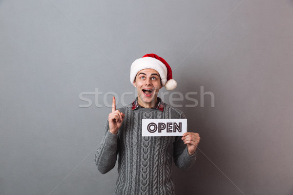 Young happy man wearing christmas santa hat Stock photo © deandrobot