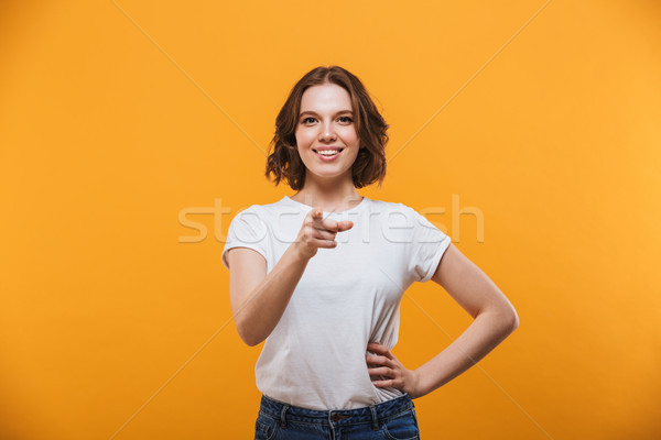 Happy emotional young woman pointing to you. Stock photo © deandrobot
